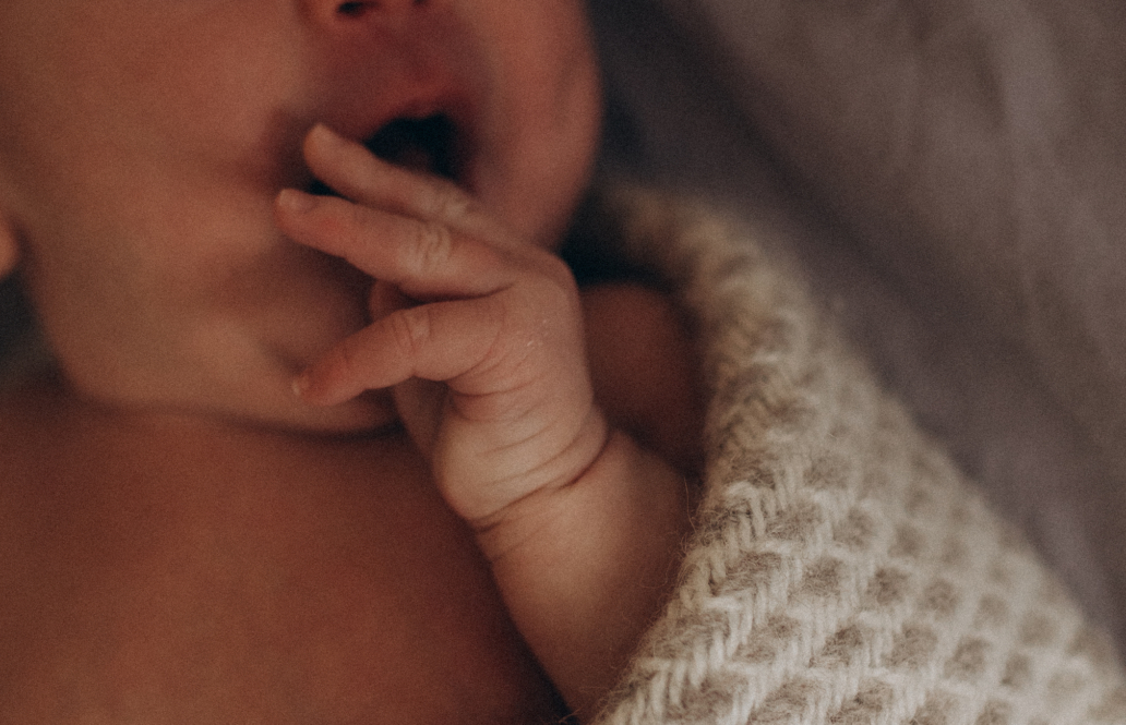 close up of tiny baby hand wrapped in white blanket new born photography amsterdam utrecht and haarlem
