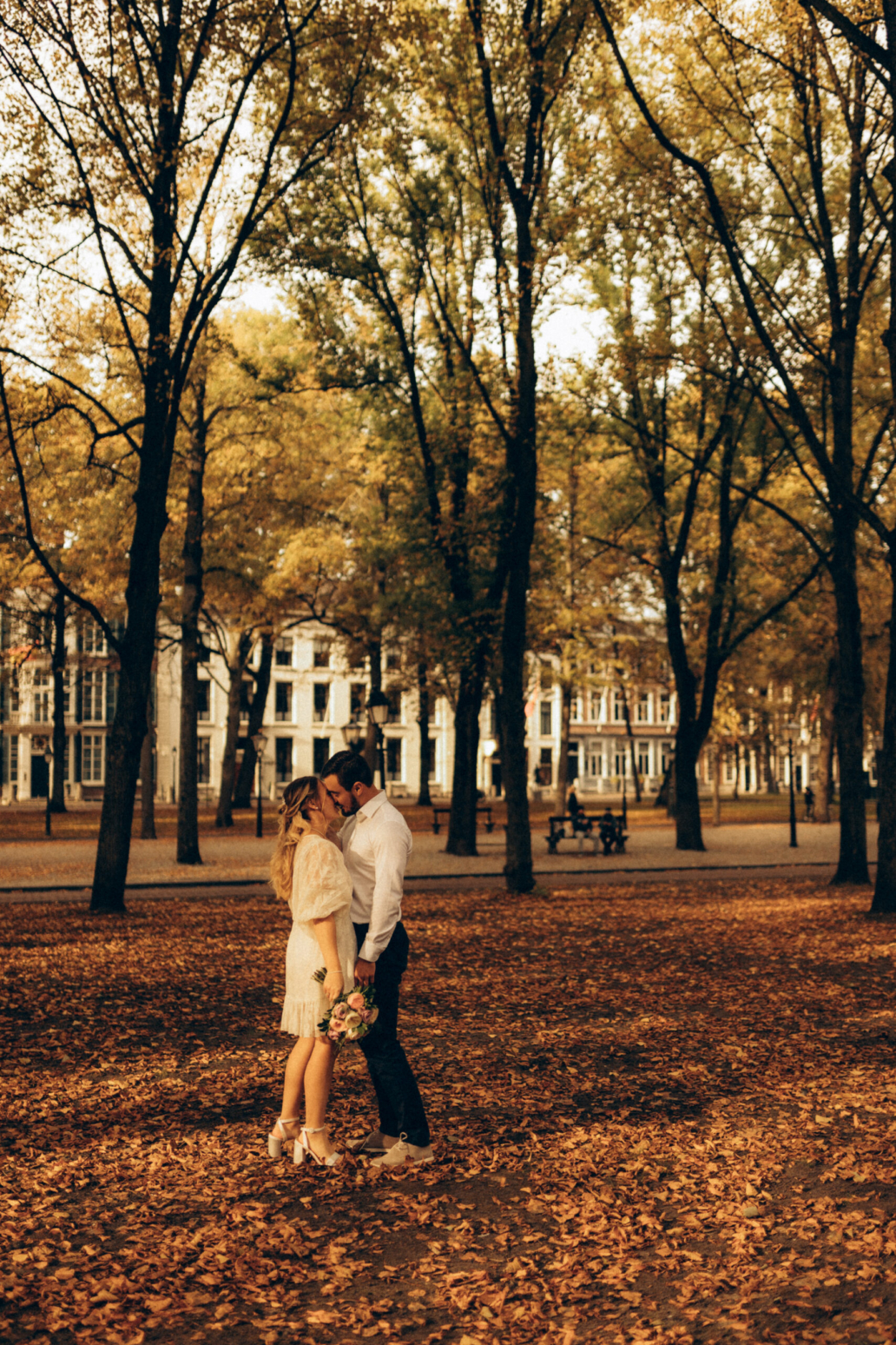 best wedding photographer couple in autumn leaves on their wedding day in the hague den haag wedding intimate photographer